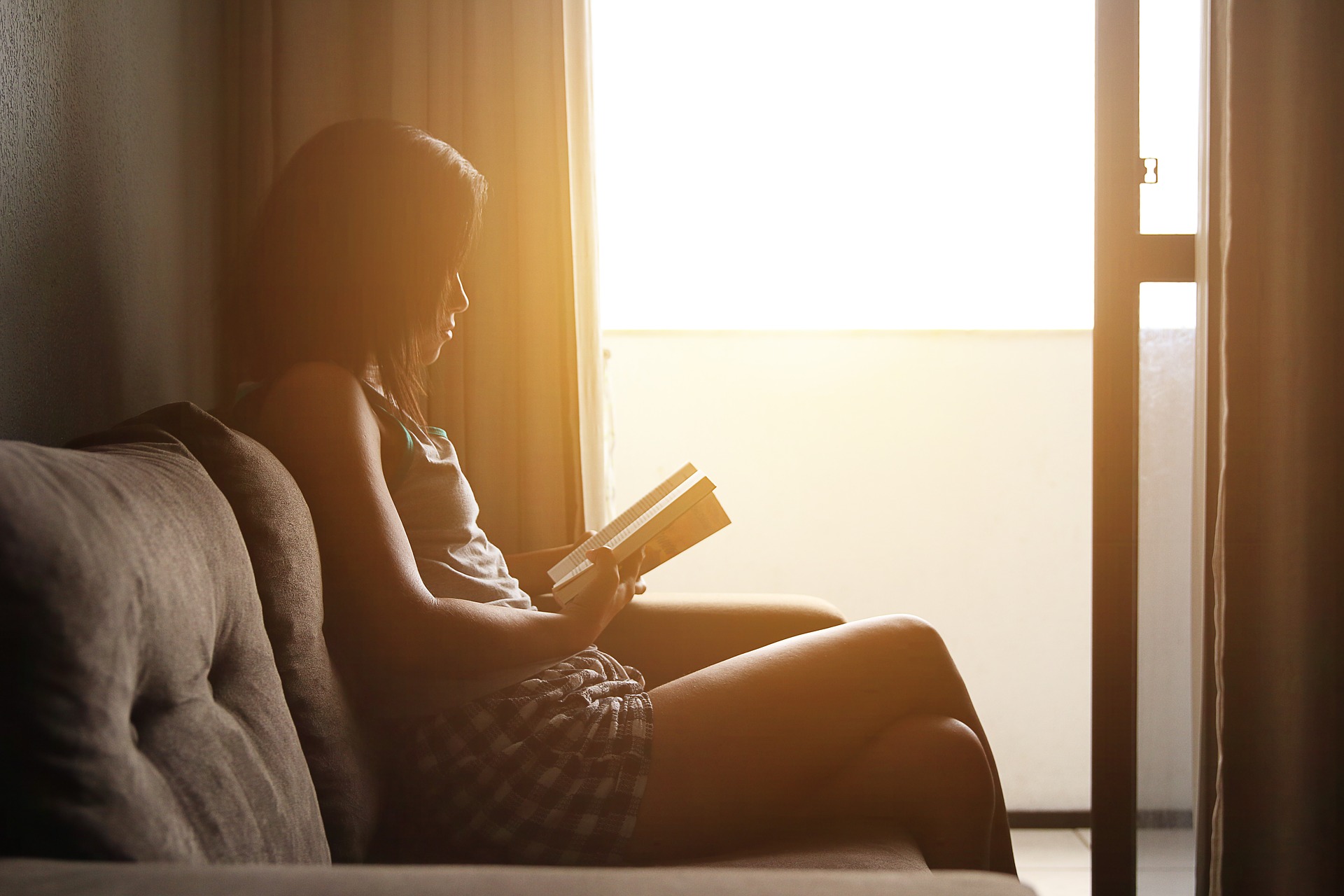 窓際で本を読む女性